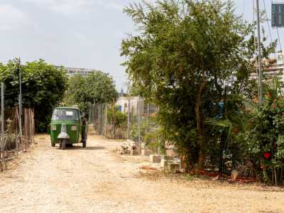 ..., ci viene incontro un traballante treruote verde carico di ferraglia